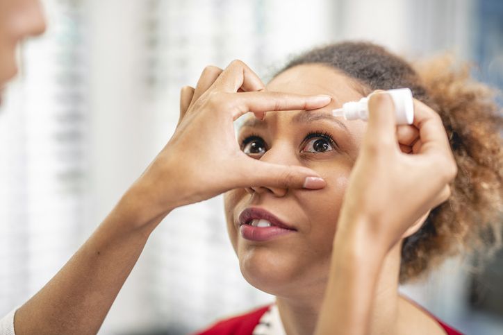 Woman applying eye drops