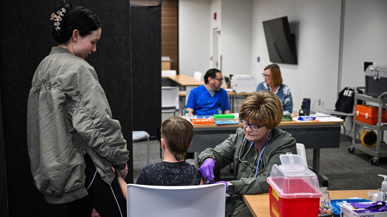 Nurse gives measles vaccine to child