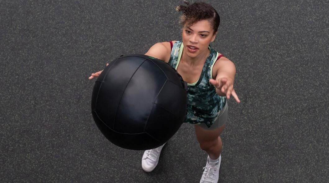 Woman performing wall ball exercise